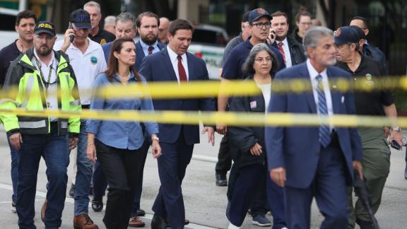 Florida Gov. Ron DeSantis, at center in the red tie, arrives to speak to the media on June 24. 