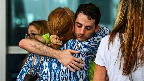 People hug at a family reunification center where evacuees were staying in Surfside.