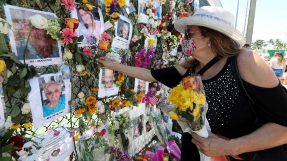 Karol Casper places a flower on the memorial wall set up near the building.